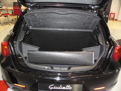 Der hochgeklappte Stoßstangenschutz schützt die Heckklappe von Giulietta während der Fahrt vor Verschmutzung und Beschädigung wie ein Schild, falls ungesicherte Gegenstände im Kofferraum  gegen die Heckklappe geschleudert werden.