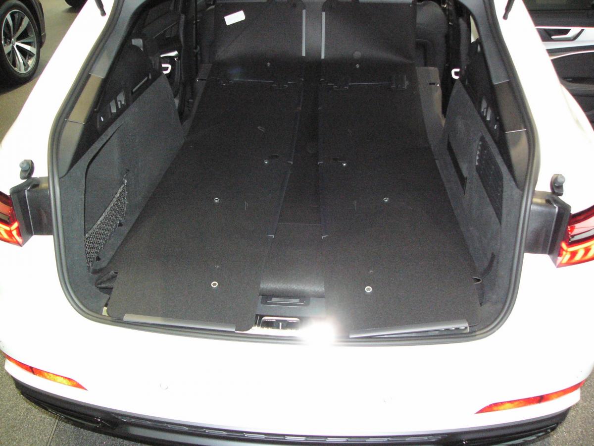 Klappen Sie die Rücksitze herunter, entfalten Sie den Kofferraumschutz bis zum Fahrersitz