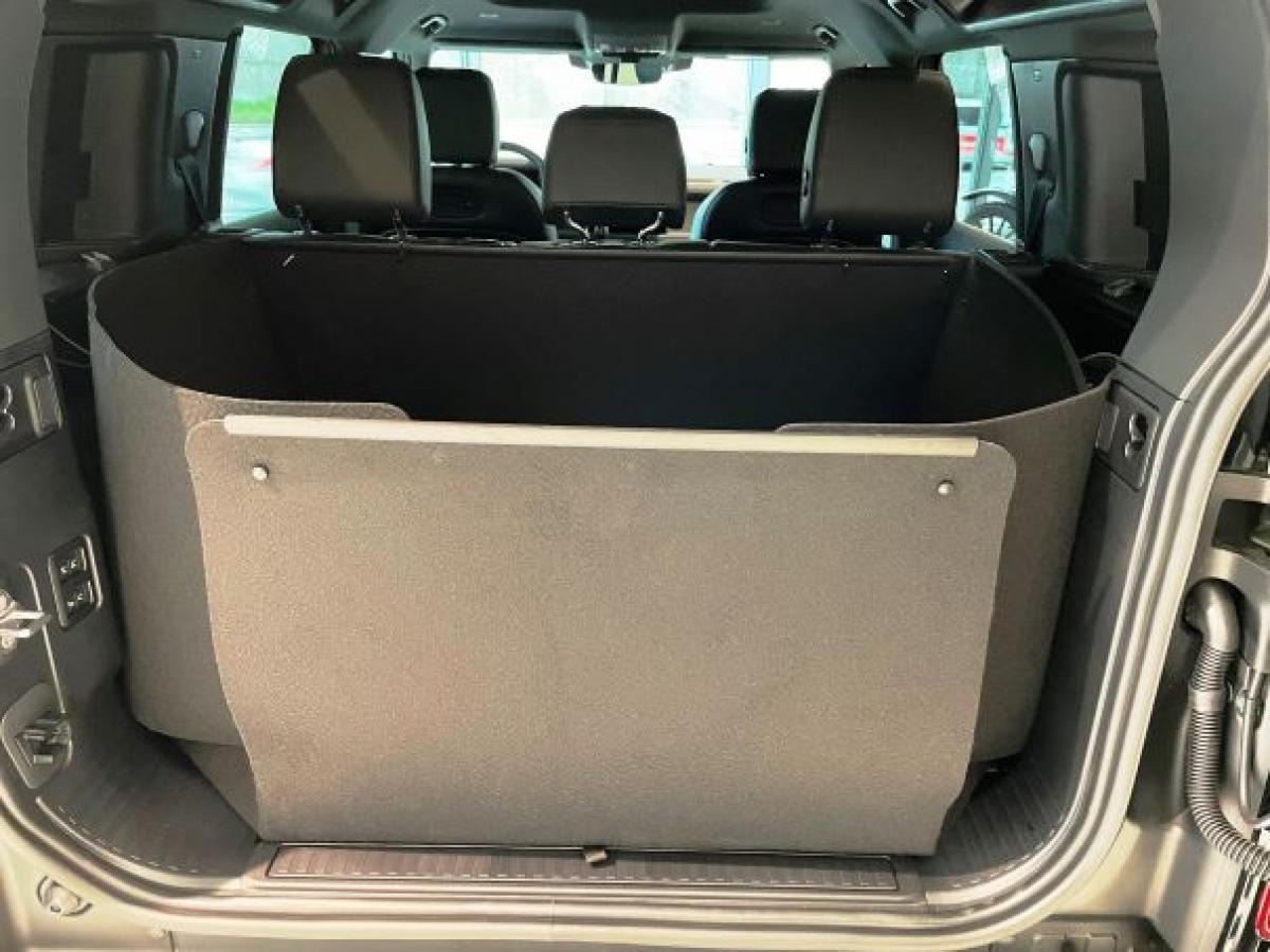 Der hochgeklappte Stoßstangenschutz schützt die Heckklappe von Land Rover Defender während der Fahrt vor Verschmutzung und Beschädigung wie ein Schild, falls ungesicherte Gegenstände im Kofferraum  gegen die Heckklappe geschleudert werden.